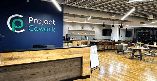Front desk and community café with wood floors and casual seating.