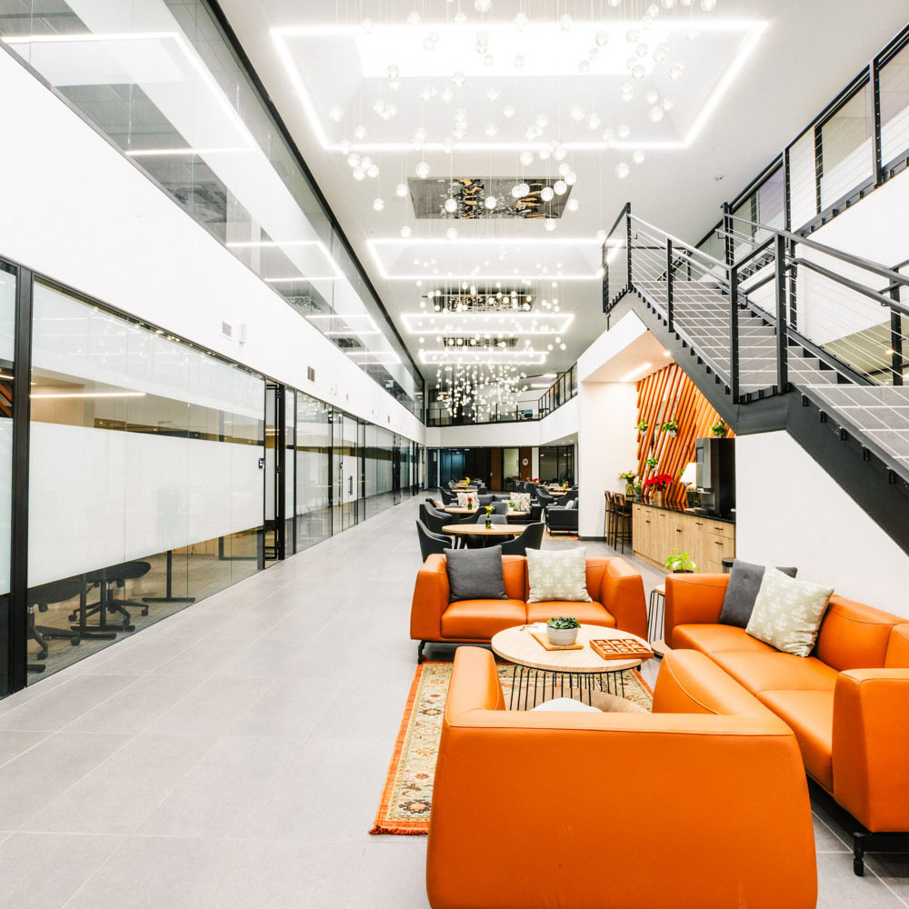Project Cowork common area with cafe seating, food prep area, and sofas