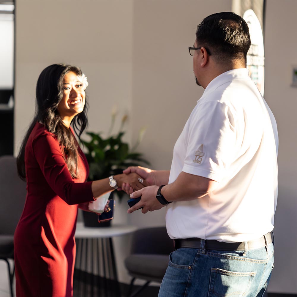 Two project cowork clients smile and shake hands