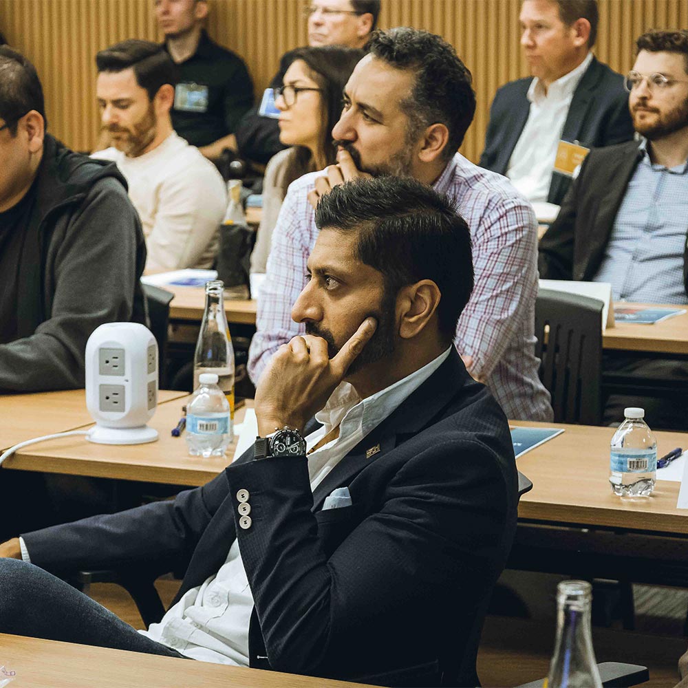 A group of participants listens to a presentation in a Project Cowork training room